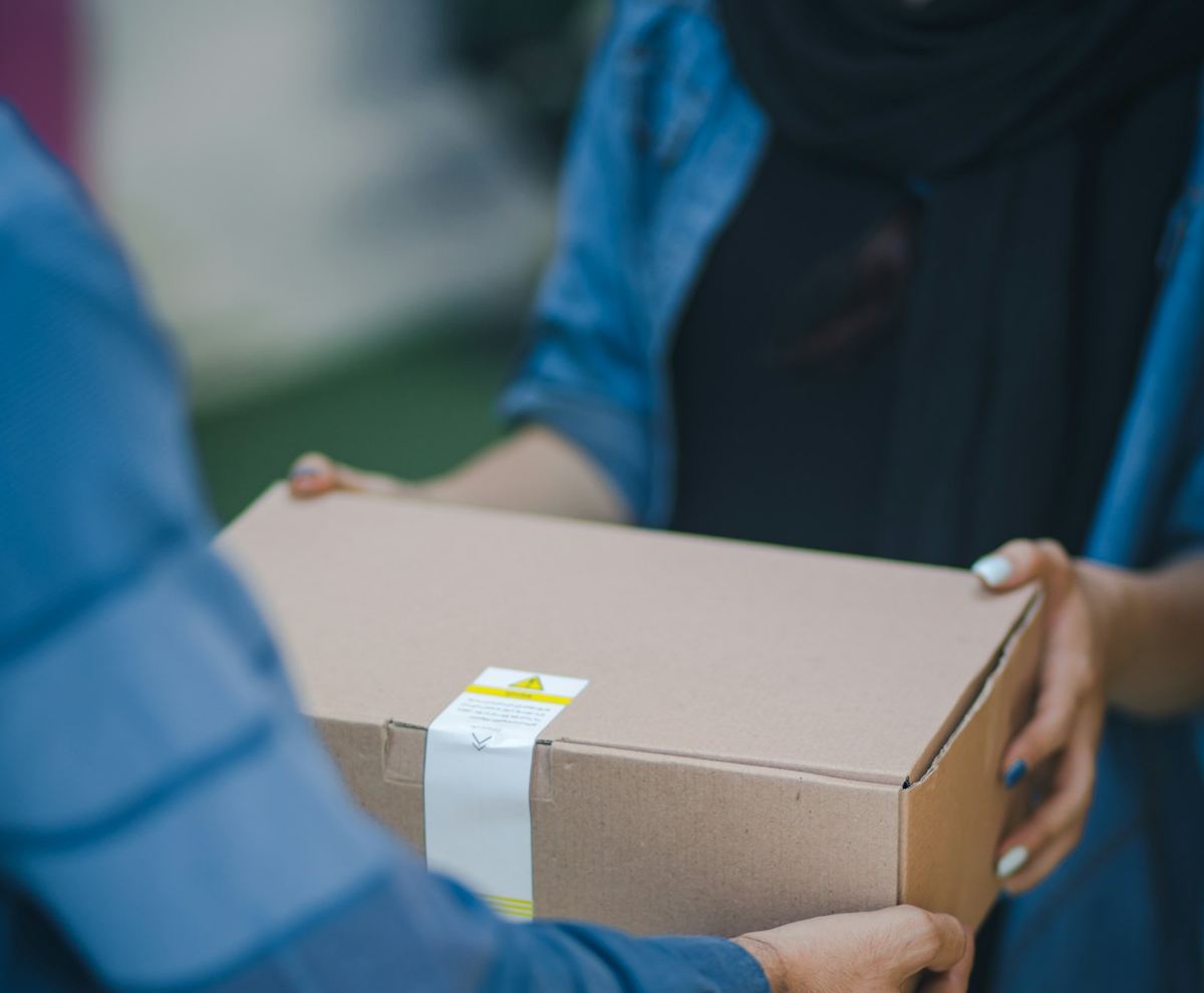 A courier handing a parcel to a customer